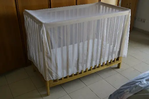 Wooden crib with mosquito net